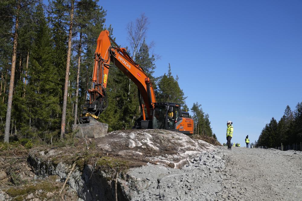 An excavator works at construction site of the border barrier fence between Finland, left, and Russia near Pelkola border crossing point in Imatra, south-eastern Finland, Friday, April 14, 2023. (AP Photo/Sergei Grits)