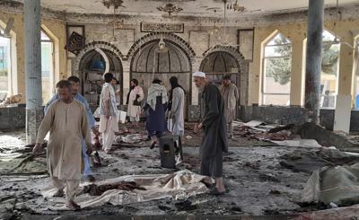 Varias personas inspeccionan los daños en el interior de una mezquita tras una explosión en Kunduz, Afganistán, el viernes 8 de octubre de 2021. (AP Foto/Abdullah Sahil)
