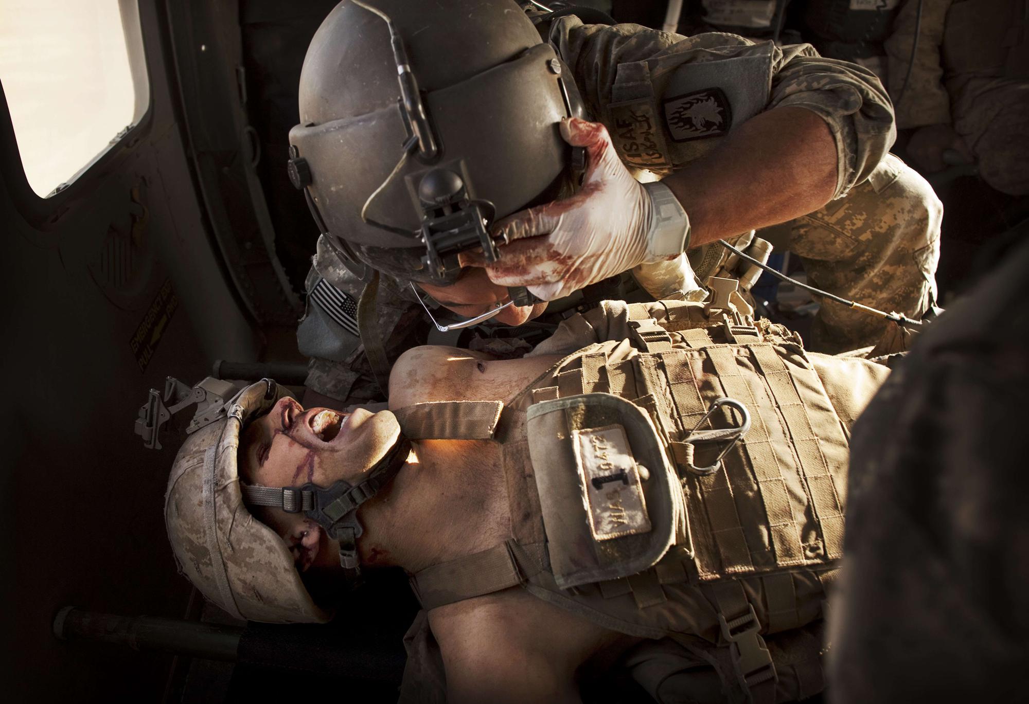 U.S. Army flight medic SGT Jaime Adame, top, cares for seriously wounded Marine CPL Andrew Smith following an insurgent attack on board a medevac helicopter Sunday, May 15, 2011, from the U.S. Army's Task Force Lift "Dust Off", Charlie Company 1-214 Aviation Regiment north of Sangin, in the volatile Helmand Province of southern Afghanistan. (AP Photo/Kevin Frayer)