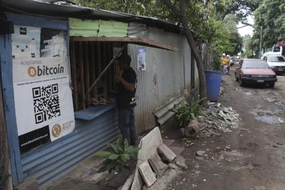 Santos Hilario Gálvez, un salvadoreño que trabaja como constructor en Hope House, una organización que patrocina el uso de criptomonedas en la playa El Zonte, realiza una compra en una pequeña tienda que acepta Bitcoin en Tamanique, El Salvador, el miércoles 9 de junio de 2021. (AP Foto/Salvador Meléndez)