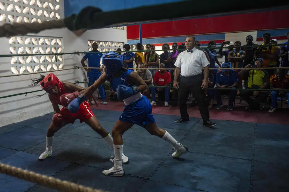 Ydamelys Moreno, izquierda, esquiva un golpe de su oponente en el primer programa oficial de boxeo femenino cubano, en la escuela de boxeo Giraldo Córdova en La Habana, Cuba, sábado 17 de diciembre de 2022. (AP Foto/Ramon Espinosa)