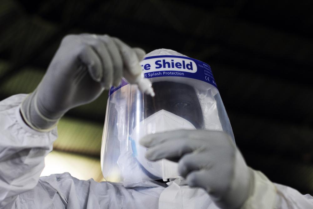 A health official takes a sample for tests at a private Covid-19 testing centre in Harare, Zimbabwe, Thursday, Feb, 3, 2022. African nations have very limited access to COVID-19 tests, especially at-home tests. In the absence of vaccines, that discrepancy has denied millions of poor people an easy way to stem the spread of the coronavirus, health officials say. (AP Photo/Tsvangirayi Mukwazhi)