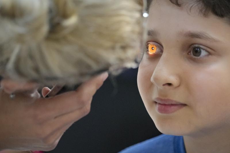 FILE - In this  Saturday, May 29, 2021 file photo, A boy undergoes an eyesight examination performed by volunteer ophthalmologists, in Nucsoara, Romania. The U.N. General Assembly approved its first-ever resolution on vision Friday, July 23, 2021 calling on its 193 member nations to ensure access to eye care for everyone in their countries which would contribute to a global effort to help at least 1.1 billion people with vision impairment who currently lack eye services by 2030. The “Vision for Everyone” resolution, sponsored by Bangladesh, Antigua and Ireland, and co-sponsored by over 100 countries, was adopted by consensus by the world body. (AP Photo/Vadim Ghirda, File)