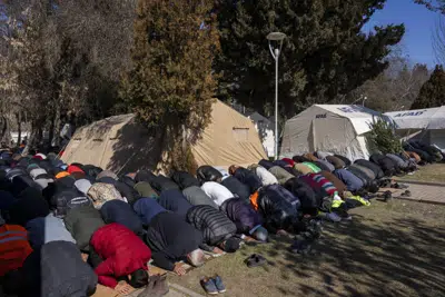 Desplazados por el terremoto asisten a la oración del viernes en un campamento en Kahramanmaras, Turquía, el viernes 17 de febrero de 2023. (AP Foto/Bernat Armangue)