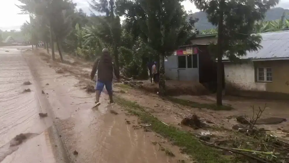 A man walks through floodwaters in western Rwanda on Tuesday, May 2, 2023. A public broadcaster in Rwanda says at more than 100 people have been killed in flooding amid torrential rain in the western and northern provinces of the country. (RwandaTV via AP)