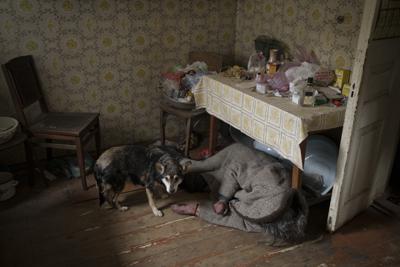 Un perro junto al cuerpo de una anciana asesinada dentro de una casa en Bucha, en las afueras de Kiev, Ucrania, el martes 5 de abril de 2022. (AP Foto/Felipe Dana)