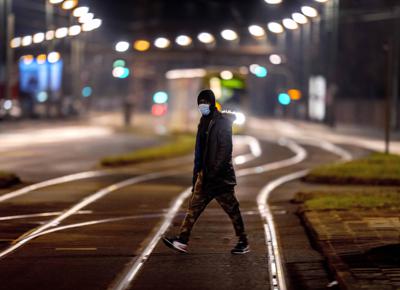 Una persona con mascarilla antiCOVID camina cerca de rieles en Fráncfort, Alemania, el 26 de diciembre del 2021. (AP foto/Michael Probst)