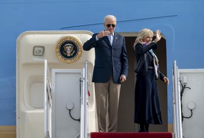 Joe Biden y su esposa Jill saludan desde la escalinata del avión presidencial antes de partir rumbo a Europa el 28 de octubre del 2021. (AP Photo/Gemunu Amarasinghe)