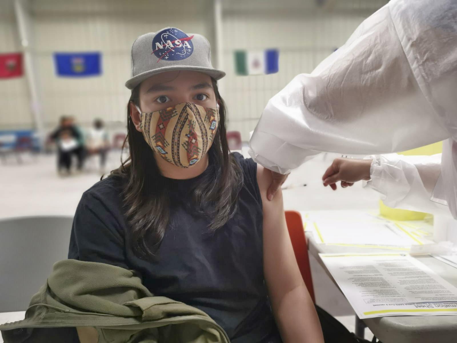 Owen Watson, 13, receives his first Pfizer COVID-19 vaccine in Iqaluit, a city in the far-north Canadian territory of Nunavut, on Wednesday, June 16, 2021. Owen said he was relieved to be able to get the vaccine. There had been no documented cases of COVID-19 in Nunavut until this spring. "It got pretty scary," he says. (AP Photo via Aaron Watson)