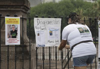 En esta imagen de archivo, tomada el 24 de junio de 2021, la familia de Ricardo Valdés, quien desapareció el 25 de mayo, coloca carteles durante una protesta en Monterrey, en el estado de Nuevo León, México. (AP Foto/Roberto Martínez, archivo)