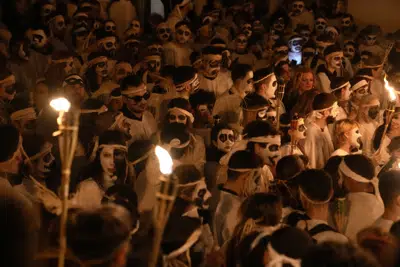 Jóvenes asisten a las celebraciones por el Carnaval en la isla de Naxos, Grecia, el sábado 25 de febrero de 2023. (AP Foto/Thanassis Stavrakis)