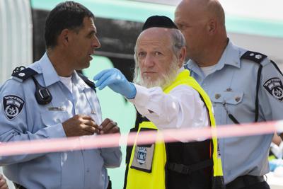 ARCHIVO - Yehuda Meshi-Zahav, jefe del servicio de rescate israelí ZAKA, centro, está en la escena de un ataque por un palestino, 13 de octubre de 2015. Meshi-Zahav, un ultraortodoxo que fue símbolo de la coexistencia hasta que su reputación se derrumbó ante una serie de denuncias de abuso sexual, ha muerto. El Centro Médico Herzog de Jerusalén confirmó su muerte el miércoles 29 de junio de 2022, sin mencionar la causa. Tenía 62 años. (AP Foto/Oded Balilty, File)