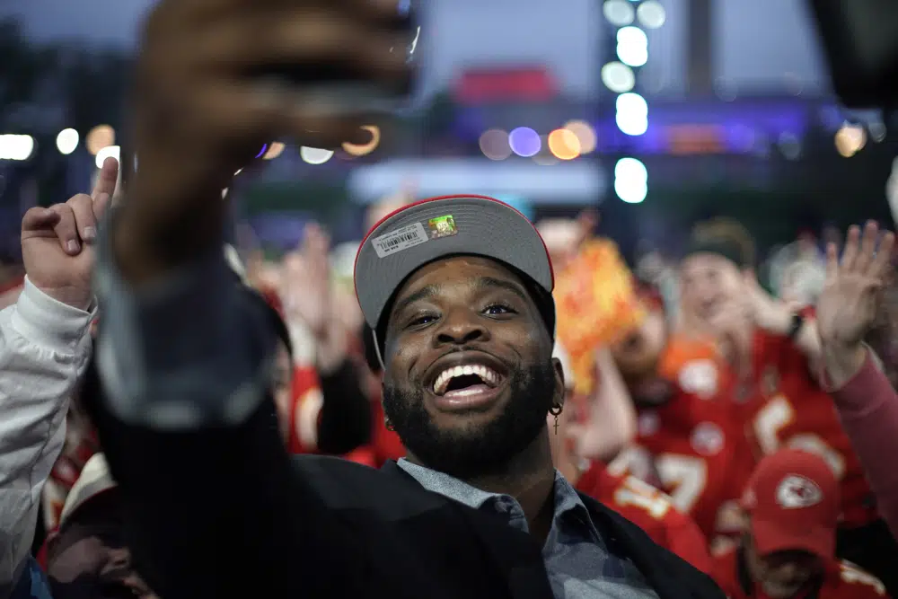 Former Kansas State defensive lineman Felix Anudike-Uzomah takes a selfie with fans during the second round of the NFL football draft, Friday, April 28, 2023, in Kansas City, Mo. Anudike-Uzomah was picked by the Kansas City Chiefs in the first round. (AP Photo/Charlie Riedel)