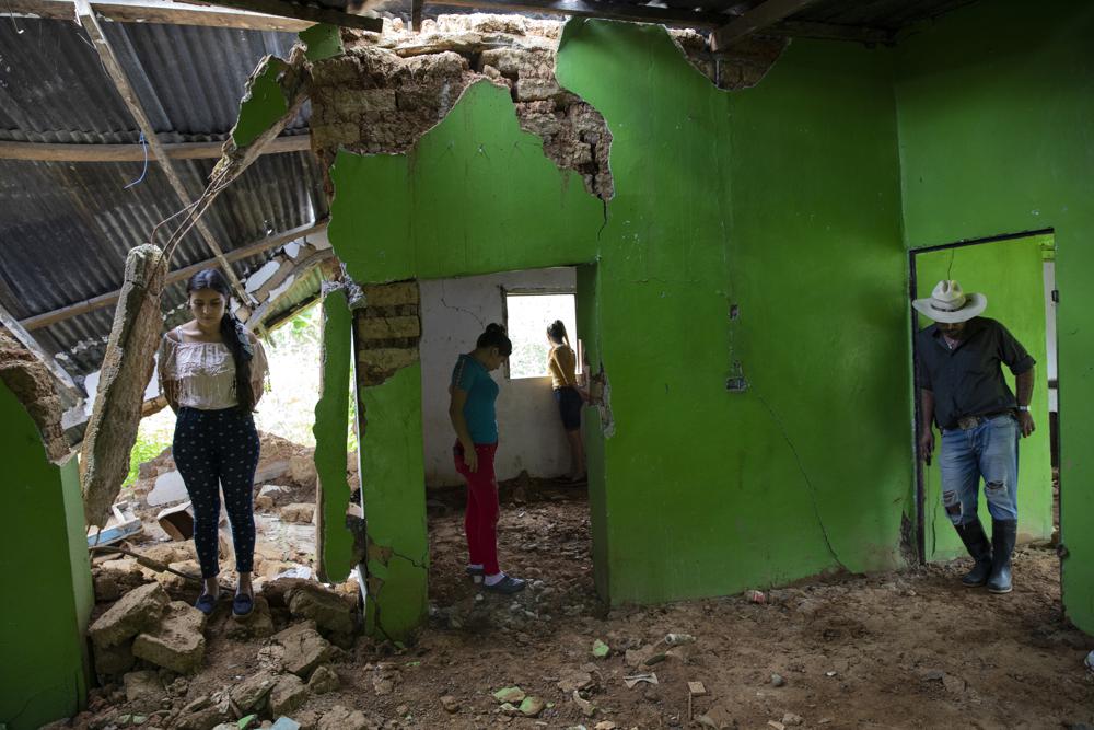 Miembros de una familia observan los destrozos causados por un deslizamiento provocado por los huracanes Eta y Iota en La Reina (Honduras)