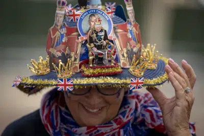 Royal enthusiast Donna Werner of the United States shows off the hat she made, while camping on the Mall, a part of the royal procession route, in central London, Thursday, May 4, 2023. The Coronation of King Charles III will take place at Westminster Abbey on May 6. (AP Photo/Vadim Ghirda)