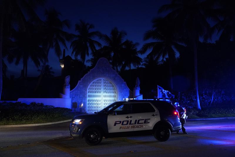Police stand outside an entrance to former President Donald Trump's Mar-a-Lago estate, Monday, Aug. 8, 2022, in Palm Beach, Fla. Trump said in a lengthy statement that the FBI was conducting a search of his Mar-a-Lago estate and asserted that agents had broken open a safe. (AP Photo/Wilfredo Lee)
