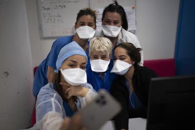 Trabajadores de hospital posan para una foto en la Unidad de Cuidados Intensivos en el hospital de la Timone en Marsella, en el sur de Francia, el sábado 25 de diciembre de 2021. El hospital, uno de los más grandes de Francia ha sufrido una ola tras otra de COVID-19. (AP Foto/Daniel Cole)
