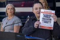 Albuquerque Police Deputy Chief of Investigations Cecily Barker holds a flyer with photos of a car wanted in connection with Muslim men murdered as Governor Michelle Lujan Grisham looks on in Albuquerque, New Mexico, Sunday, Aug. 7, 2022. Authorities investigating the killings of four Muslim men said they are looking for help finding a vehicle believed to be connected to the deaths in New Mexico's largest city. A Muslim man was killed Friday, Aug. 5, 2022, in Albuquerque, and ambush shootings killed three other Muslim men over the past nine months. (Adolphe Pierre-Louis/Albuquerque Journal via AP)