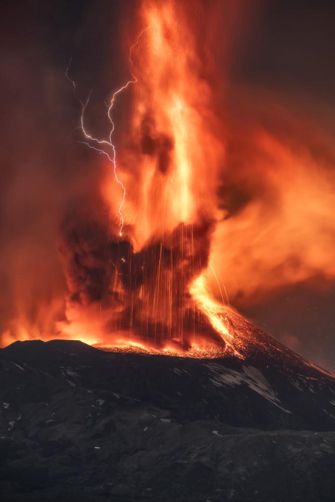 A volcanic thunderstorm over Mt. Etna, Sicily, Italy, generates volcanic lightning during an eruption, early Friday, Feb. 11, 2022. Colliding particles of volcanic ash generate static electricity that discharges within the volcanic plume. (AP Photo/Emilio Messina)