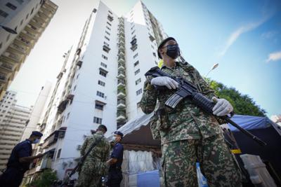 Soldados armados montan guardia fuera del área residencial de Pangsapuri Permai, colocada bajo confinamiento debido al drástico aumento en el número de casos de COVID-19 durante los últimos 10 días en Cheras, en los alrededores de Kuala Lumpur, Malasia, el viernes 28 de mayo de 2021. (AP Foto/Vincent Thian)