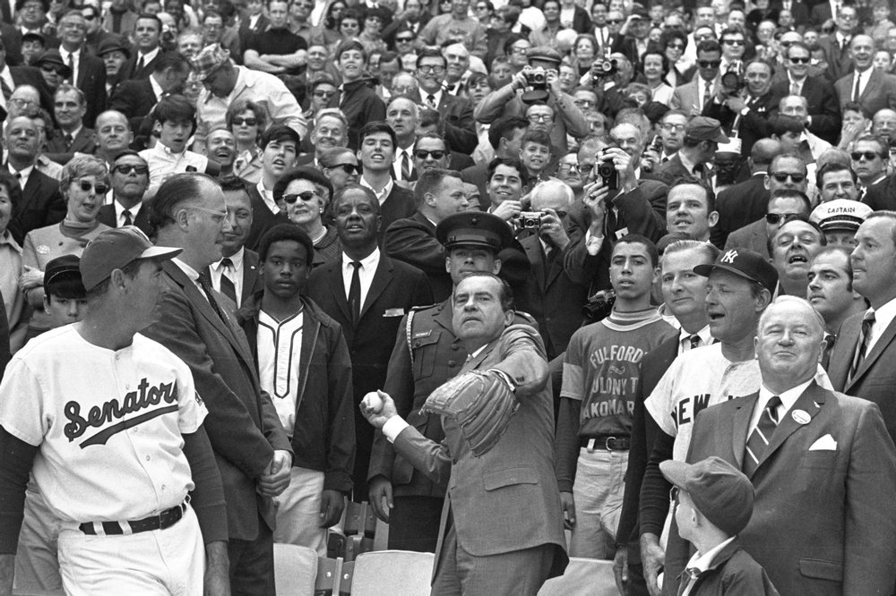 FILE - In this April 7, 1969, file photo, President Richard M. Nixon throws out the ceremonial first pitch in Washington as Baseball Commissioner Bowie Kuhn, second from left, and Washington Senators manager Ted Williams, far left, watch. (AP Photo/File)