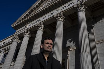 Miguel Hurtado, quien ha hecho campaña contra la impunidad desde que reveló sus propias denuncias de haber sido víctima de abuso sexual en un monasterio en el noreste de España, posa para una fotografía frente al Parlamento español en Madrid, España, el martes 1 de febrero de 2022. (AP Foto/Manu Fernández)