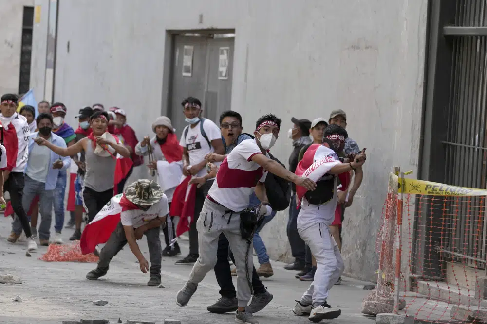 Manifestantes opositores que viajaron a la capital desde otras partes del país para marchar contra la presidenta peruana Dina Boluarte se enfrentan a la policía en Lima, Perú, el jueves 19 de enero de 2023. Las protestas buscan un adelanto electoral inmediato, la renuncia de Boluarte, la liberación del presidente destituido Pedro Castillo y justicia por los al menos 48 manifestantes muertos en enfrentamientos con la policía. (AP Foto/Martín Mejía)