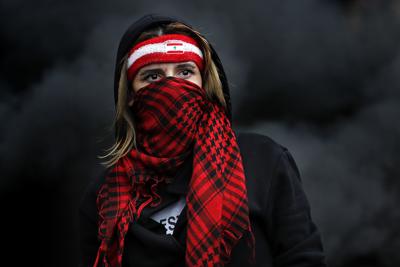 Una joven se cubre el rostro con una bufanda durante manifestaciones antigubernamentales en Zouk Mosbeh, al norte de Beirut, el 8 de marzo del 2021. (AP Photo/Hussein Malla, File)