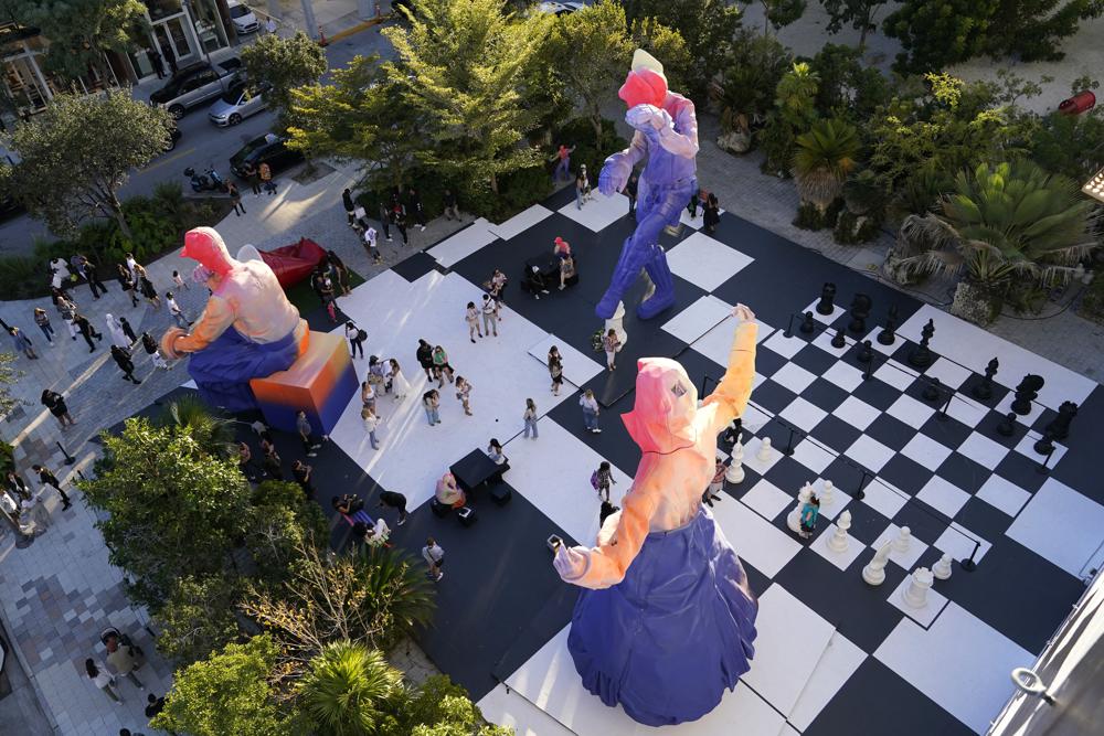 Sculptures and a giant chess set decorate a plaza as part of a Louis Vuitton art installation during Miami Art Week, Friday, Dec. 3, 2021, in the Design District neighborhood of Miami. The project was done under late designer Virgil Abloh who died Sunday at age 41 after a lengthy battle with cancer. Art Week is an annual event centered around the Art Basel Miami Beach fair. (AP Photo/Lynne Sladky)