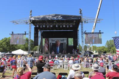 El expresidente Donald Trump habla con la concurrencia vía video el 12 de junio del 2021 en New Richmond, Wisconsin. El evento fue organizado por el empresario de almohadas y promotor de teorías de conspiración Mike Lindell. Por unas pocas horas el pasado fin de semana, miles de partidarios de Donald Trump se congregaron en un campo bajo el intenso sol de Wisconsin para vivir una realidad alternativa en la que el expresidente seguía en el puesto _ o regresaría pronto.  (AP Foto/Jill Colvin)