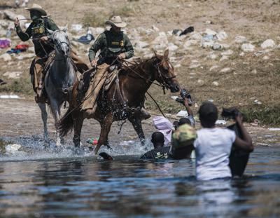 Guardias fronterizos a caballo tratan de impedir el paso de migrantes que cruzan el río Bravo desde Ciudad Acuña, México, a Del Rio, Texas, 19 de setiembre de 2021. (AP Foto/Felix Marquez)