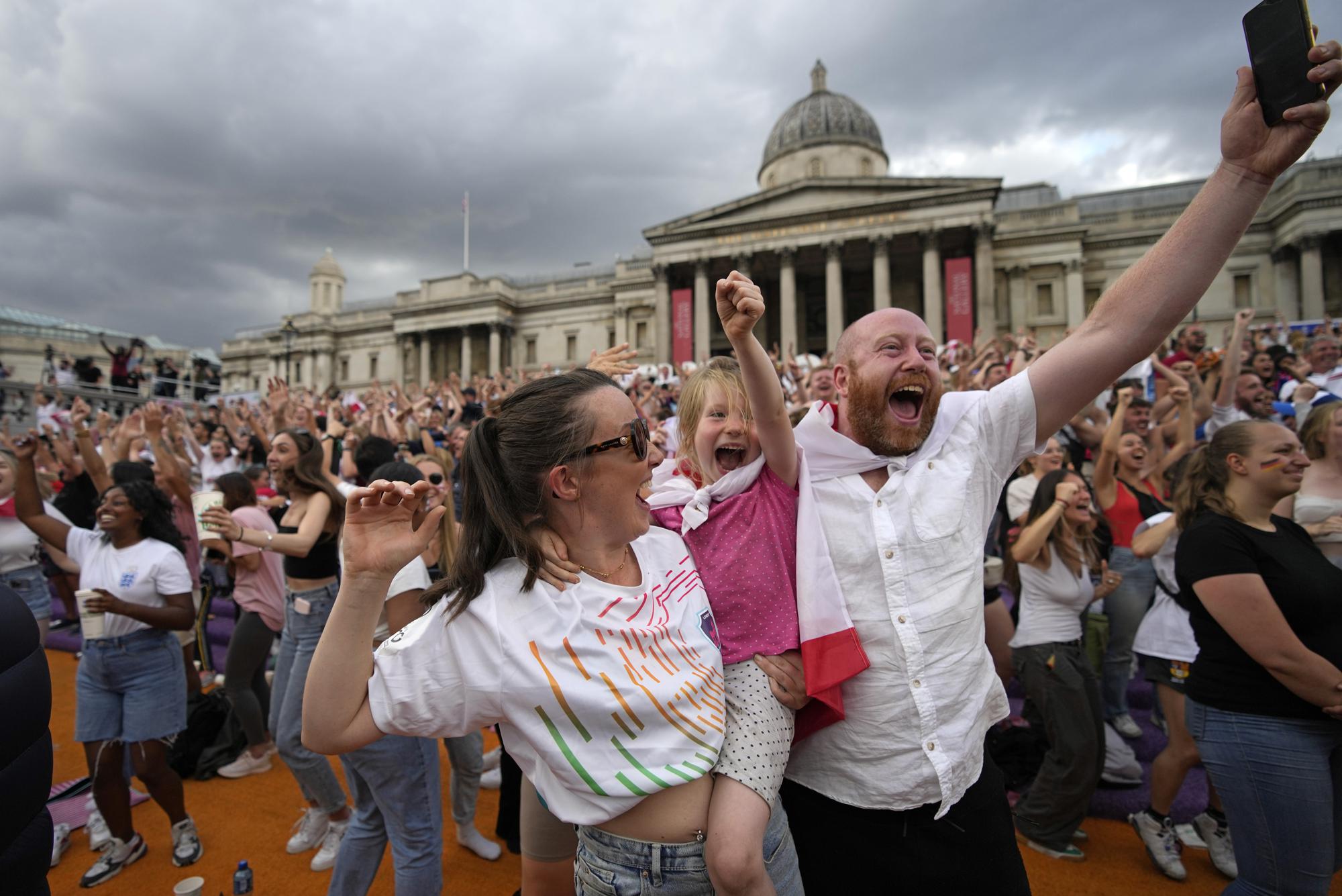 FILE - England supporters celebrate after Chloe Kelly scored their second goal as they gather in the fan zone in Trafalgar Square to watch on a big screen the final of the Women's Euro 2022 soccer match between England and Germany being played at Wembley stadium in London, Sunday, July 31, 2022. (AP Photo/Frank Augstein, File)