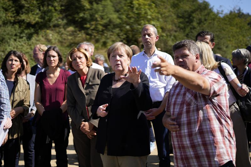 German Chancellor Angela Merkel, center, gestures besides Malu Dreyer, Prime Minister of Rhineland-Palatinate, left, and mayor Ruediger Fuhrmann during their visit to the flood-damaged Altenahr, Germany, Friday, Sept. 3, 2021. After days of extreme downpours causing devastating floods hit the valley of the river Ahr in July. (AP Photo/Markus Schreiber, Pool)