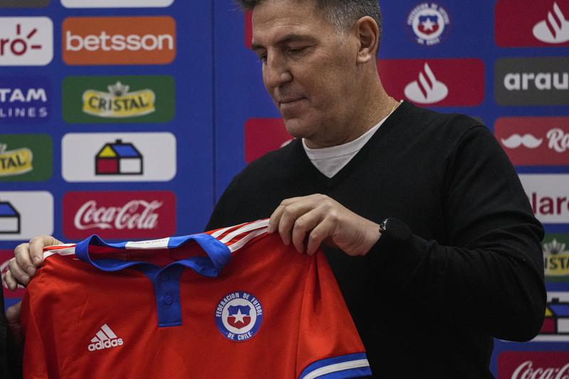 El argentino Eduardo Berizzo sostiene su nueva camiseta al ser presentada como el nuevo técnico de la selección chilena de fútbol, ​​en una conferencia de prensa en Santiago, Chile, el lunes 30 de mayo de 2022. (AP Foto/Esteban Félix)