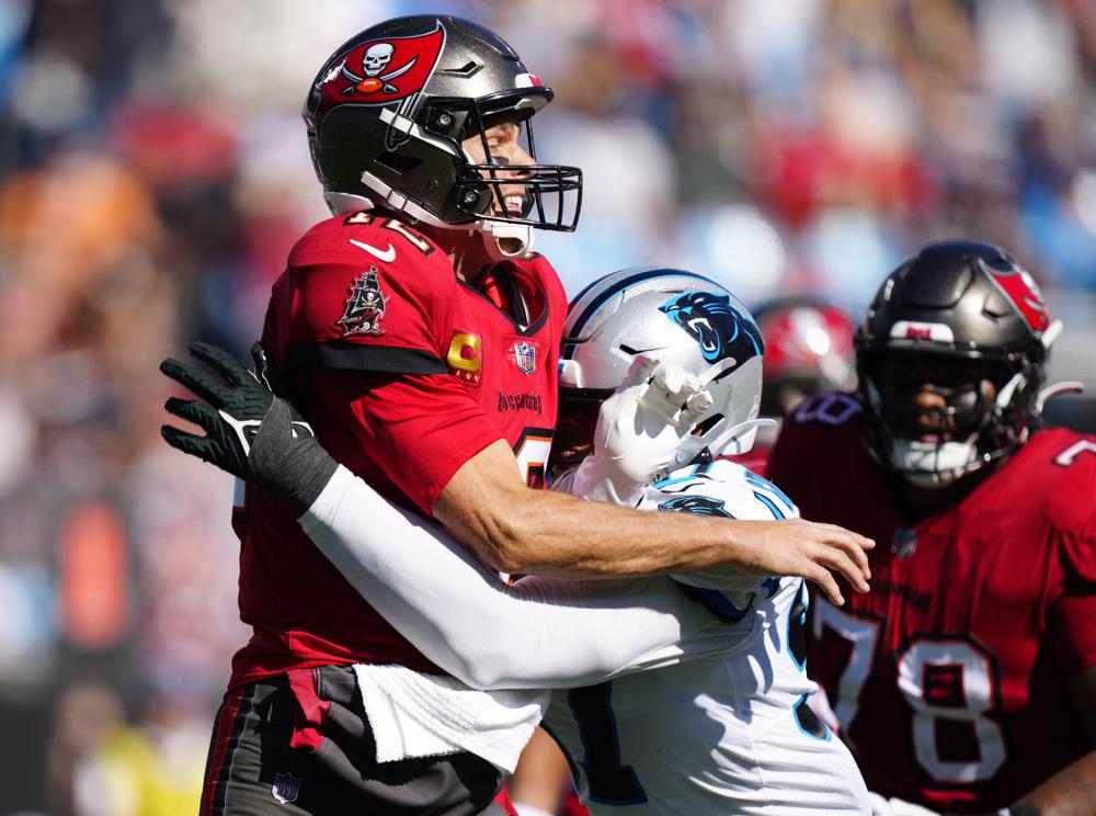 Carolina Panthers defensive end Yetur Gross-Matos, right, pressures Tampa Bay Buccaneers quarterback Tom Brady (12) after a pass during the second half of an NFL football game Sunday, Oct. 23, 2022, in Charlotte, N.C. (AP Photo/Jacob Kupferman)