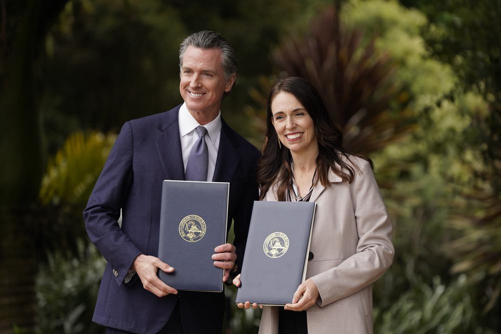 California Gov. Gavin Newsom and New Zealand Prime Minister Jacinda Ardern pose with agreements they signed at the San Francisco Botanical Garden in San Francisco, Friday, May 27, 2022. Gov. Newsom met with Ardern in Golden Gate Park "to establish a new international partnership tackling climate change." (AP Photo/Eric Risberg)