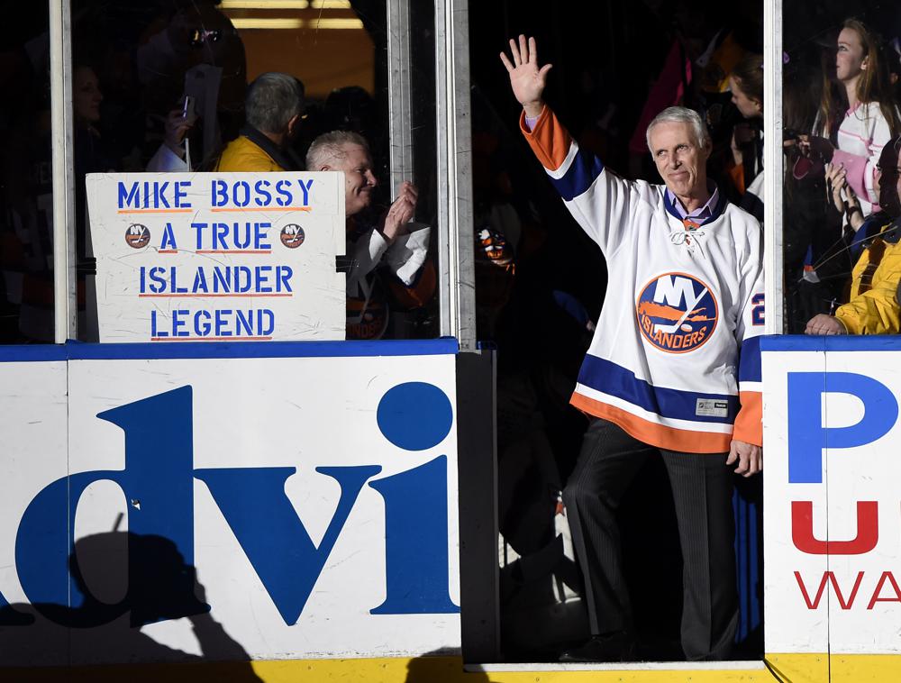 FILE - Hockey Hall of Famer and former New York Islander Mike Bossy waves to fans as he is introduced before the NHL hockey game between the Islanders and the Boston Bruins at Nassau Coliseum on Thursday, Jan. 29, 2015, in Uniondale, N.Y. Bossy dropped a ceremonial first puck. Bossy, one of hockey’s most prolific goal-scorers and a star for the New York Islanders during their 1980s dynasty, died Thursday, April 14, 2022, after a battle with lung cancer. He was 65. (AP Photo/Kathy Kmonicek, File)