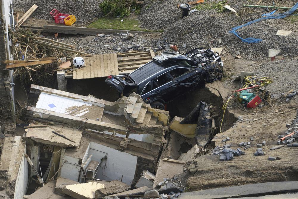 FILE - Houses and cars in the Ahr valley in the Walporzheim district are destroyed in Bad Neuenahr-Ahrweiler, Germany, on July 17, 2021, after days of heavy rain and flooding. A special United Nations panel is putting the finishing touches on a major science report that's supposed to tell people the "so what?" about climate change. The report will highlight how global warming disrupts people's lives, their natural environment and Earth itself. (Thomas Frey/dpa via AP)