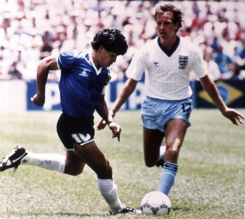 ARCHIVO - Diego Maradona (izquierda) esquiva al inglés Trevor Steven durante el partido de la Copa Mundial en el Estadio Azteca, el 22 de junio de 1986. La camiseta que usó el astro argentino en ese partido, en el que el controvertido gol de la “mano de Dios” y luego el mejor gol de la historia de los mundiales está en venta, y la subastadora Sotheby's estima que recaudará más de 4 millones de libras (5,2 millones de dólares) en una subasta online que comienza el 20 de abril.  (Foto AP)