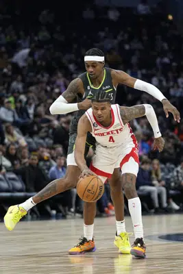 Houston Rockets guard Jalen Green (4) handles the ball while defended by Minnesota Timberwolves forward Jaden McDaniels (3) during the second half of an NBA basketball game, Saturday, Jan. 21, 2023, in Minneapolis. (AP Photo/Abbie Parr)