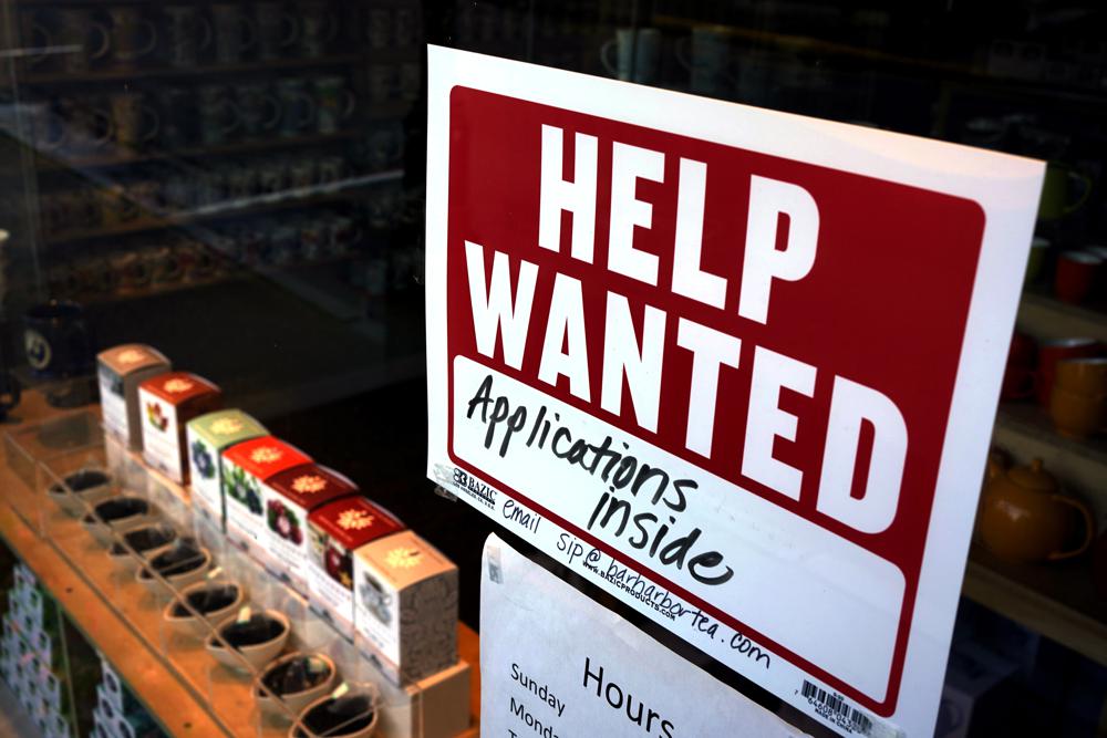 FILE - A help-wanted sign hangs in the front window of the Bar Harbor Tea Room, Saturday, June 11, 2022, in Bar Harbor, Maine.  America’s employers shrugged off high inflation and weakening growth to add 372,000 jobs in June, a surprisingly strong gain that will likely spur the Federal Reserve to keep sharply raising interest rates to try to cool the economy and slow price increases. The unemployment rate remained at 3.6% for a fourth straight month, the government said Friday, July 8.  (AP Photo/Robert F. Bukaty, File)