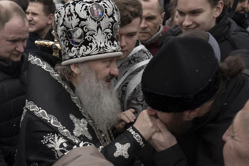A senior priest of the Ukrainian Orthodox Church blesses parishioners in the Kyiv Pechersk Lavra monastery complex in Kyiv, Ukraine, Wednesday, March 29, 2023. The Russian invasion of Ukraine is reverberating in a struggle for control of a monastery complex. The government says it's evicting the Ukrainian Orthodox Church from the complex as of March 29, accusing it of pro-Russia actions and ideology. (AP Photo/Andrew Kravchenko)