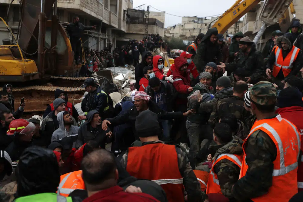 Civil defense workers and security forces carry an earthquake victim as they search through the wreckage of collapsed buildings in Hama, Syria, Monday, Feb. 6, 2023. A powerful earthquake has caused significant damage in southeast Turkey and Syria and many casualties are feared. Damage was reported across several Turkish provinces, and rescue teams were being sent from around the country. (AP Photo/Omar Sanadiki)