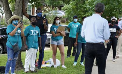 Voluntarios de la organización Texas Organizing Project escuchan a Beto O'Rourke (de espaldas) antes de una caminata de barrio en West Dallas el miércoles 9 de junio de 2021. El excongresista y candidato a senador conduce una campaña para reunir apoyo de los votantes a fin de detener una iniciativa de ley del voto de Texas, la SB7. (AP Foto/LM Otero)