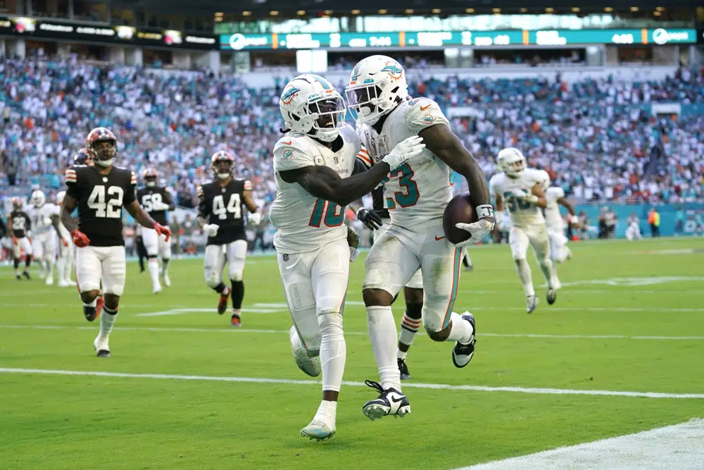 Miami Dolphins running back Jeff Wilson Jr. (23) is congratulated by wide receiver Tyreek Hill (10) after Wilson scores a touchdown during the second half of an NFL football game, Sunday, Nov. 13, 2022, in Miami Gardens, Fla. (AP Photo/Lynne Sladky)