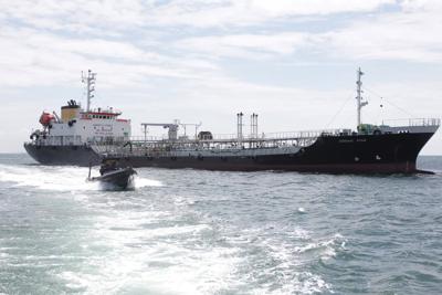 En esta imagen sin fecha publicada por la Marina indonesia, un bote de la Marina pasa junto al petrolero con bandera panameña MT Zodiac Star, anclado en aguas de la isla de Riau, Indonesia. La Marina de Indonesia detuvo un enorme petrolero que se cree transporta miles de toneladas de hidrocarburos de desecho y llevó el barco a la costa para continuar la investigación, según dijeron las autoridades el jueves 2 de septiembre. (Marina indonesia via AP)