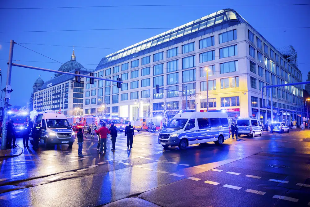 Police officers block a street after a huge aquarium burst at the Seal Life Aquarium in central Berlin, Germany, Friday, Dec. 16, 2022. (Christoph Soeder/dpa via AP)