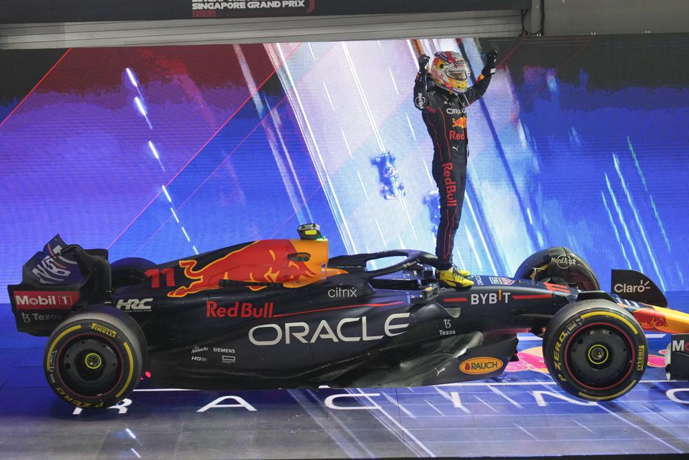 El mexicano Sergio Pérez celebra sobre su Red Bull tras ganar el Gran Premio de Singapur, el domingo 2 de octubre de 2022. (AP Foto/Vincent Thian)