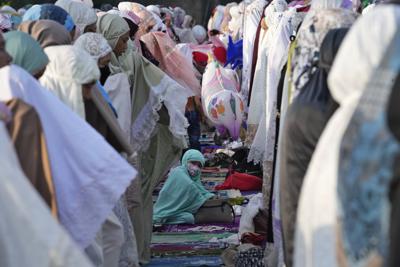 Una mujer musulmana durante la oración del Eid al-Fitr que marca el final del mes sagrado de ayuno, el ramadán, en el puerto de Sunda Kelapa, en Yakarta, Indonesia, el 2 de mayo de 2022. (AP Foto/Tatan Syuflana)