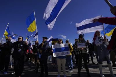 Russian protesters living in Cyprus wave Ukrainian and Russian national flags without the red stripe, during a protest against Russia's invasion of Ukraine, in southern port city of Limassol, Cyprus, Sunday, March 13, 2022. Dozens of Russian nationals joined Ukrainians in the coastal resort town of Limassol Sunday to protest the war in Ukraine, chanting slogans like "Stop the war, stop Putin" and waving blue and white flags they said where the Russian national flag without the red stripe that represented "blood and violence." (AP Photo/Petros Karadjias)